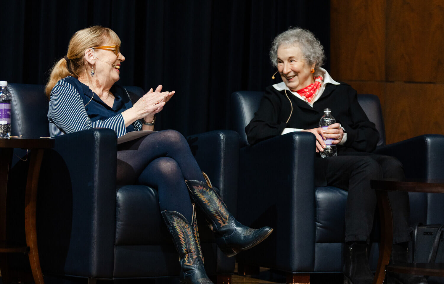 Two woman sit in chairs talking