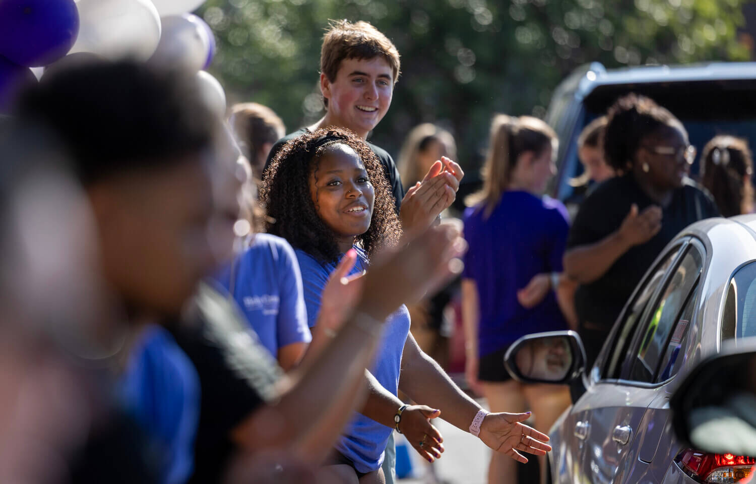 Students clapping as cars drive up