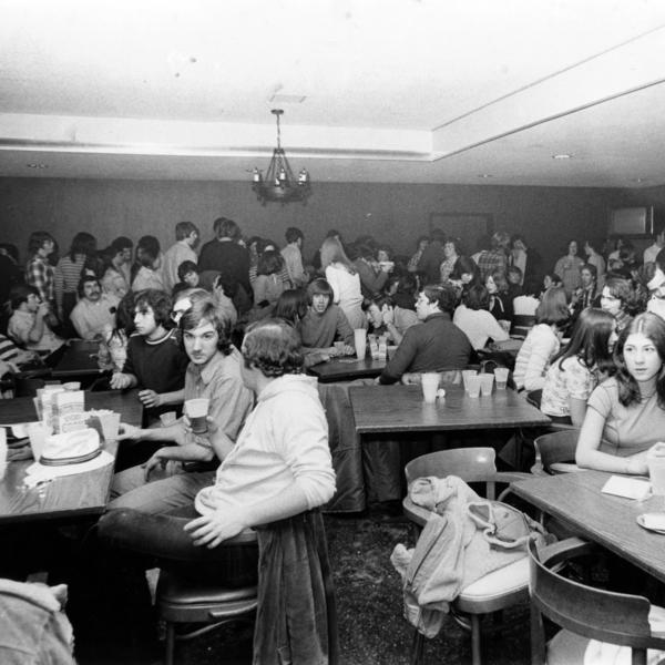 A large group of people within a dining hall or cafeteria 