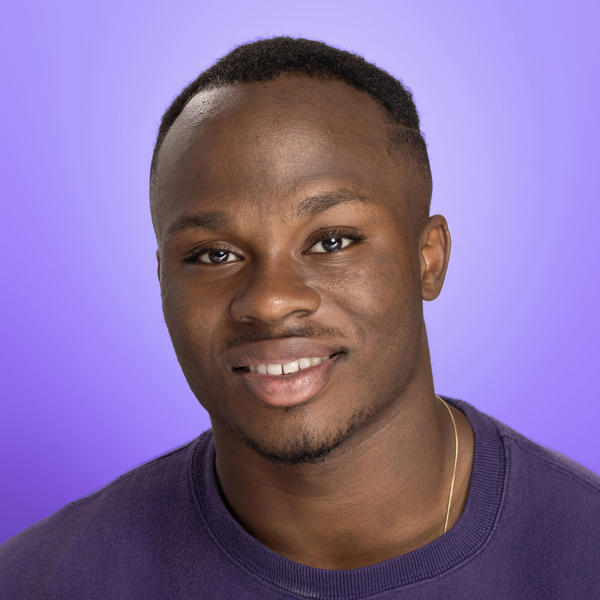 A portrait of a smiling young man wearing a Holy Cross sweatshirt