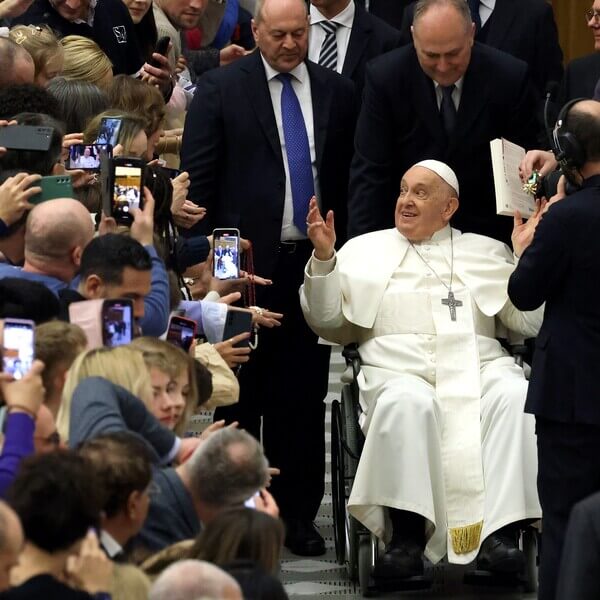 Man in wheelchair pushed through a crowd
