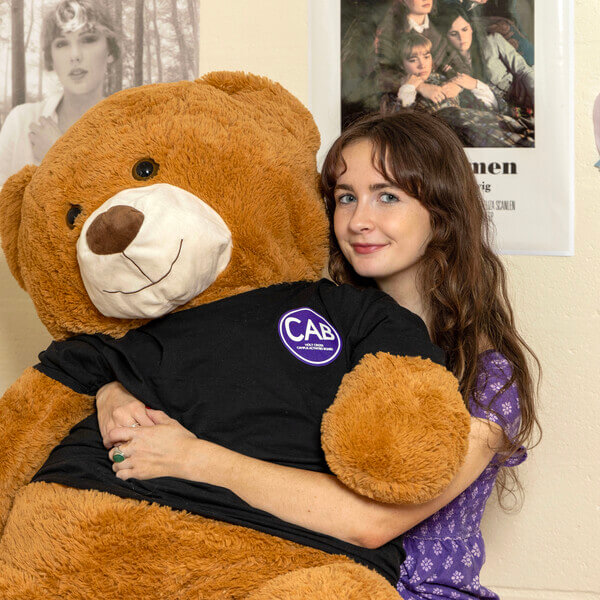 Annabeth holds her bingo prize, CAB, a giant stuffed bear