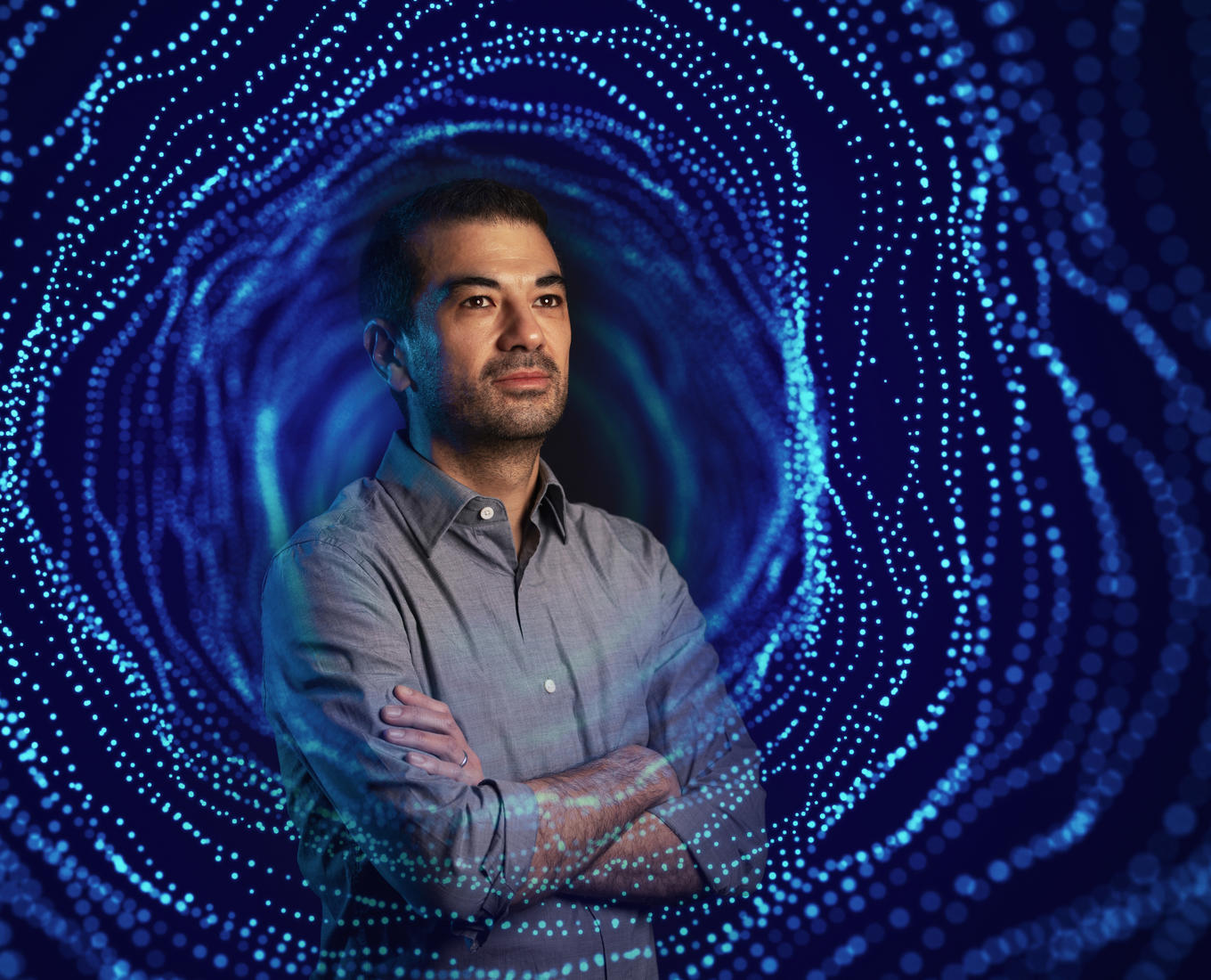 A portrait of a physics professor with a projection of a wormhole overlayed 