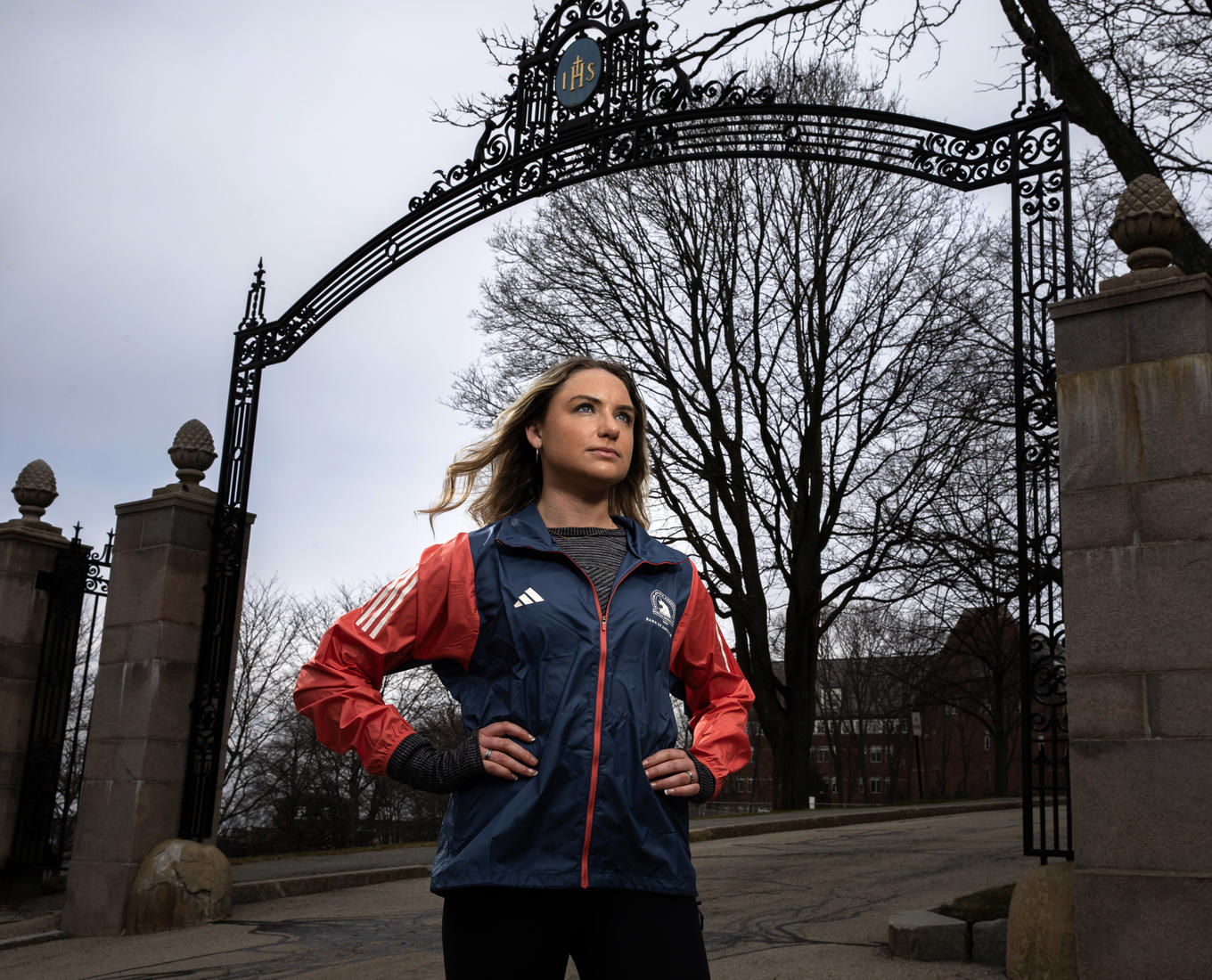 A female runner looking away with hands on her hips