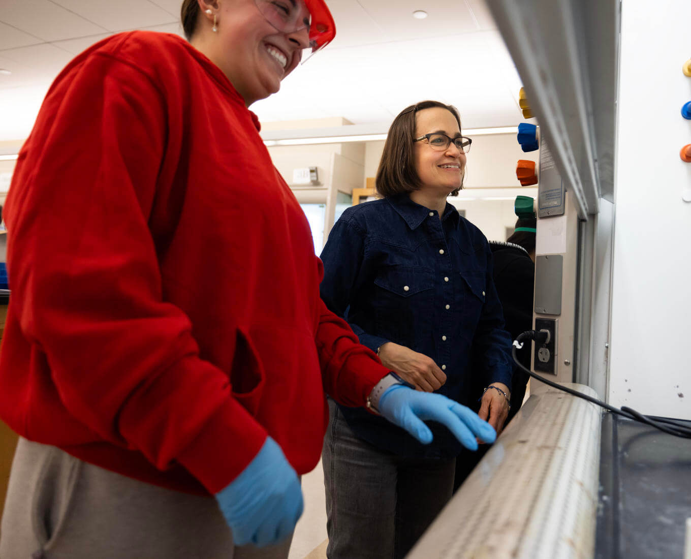 Chemistry student works alongside her professor in a lab.