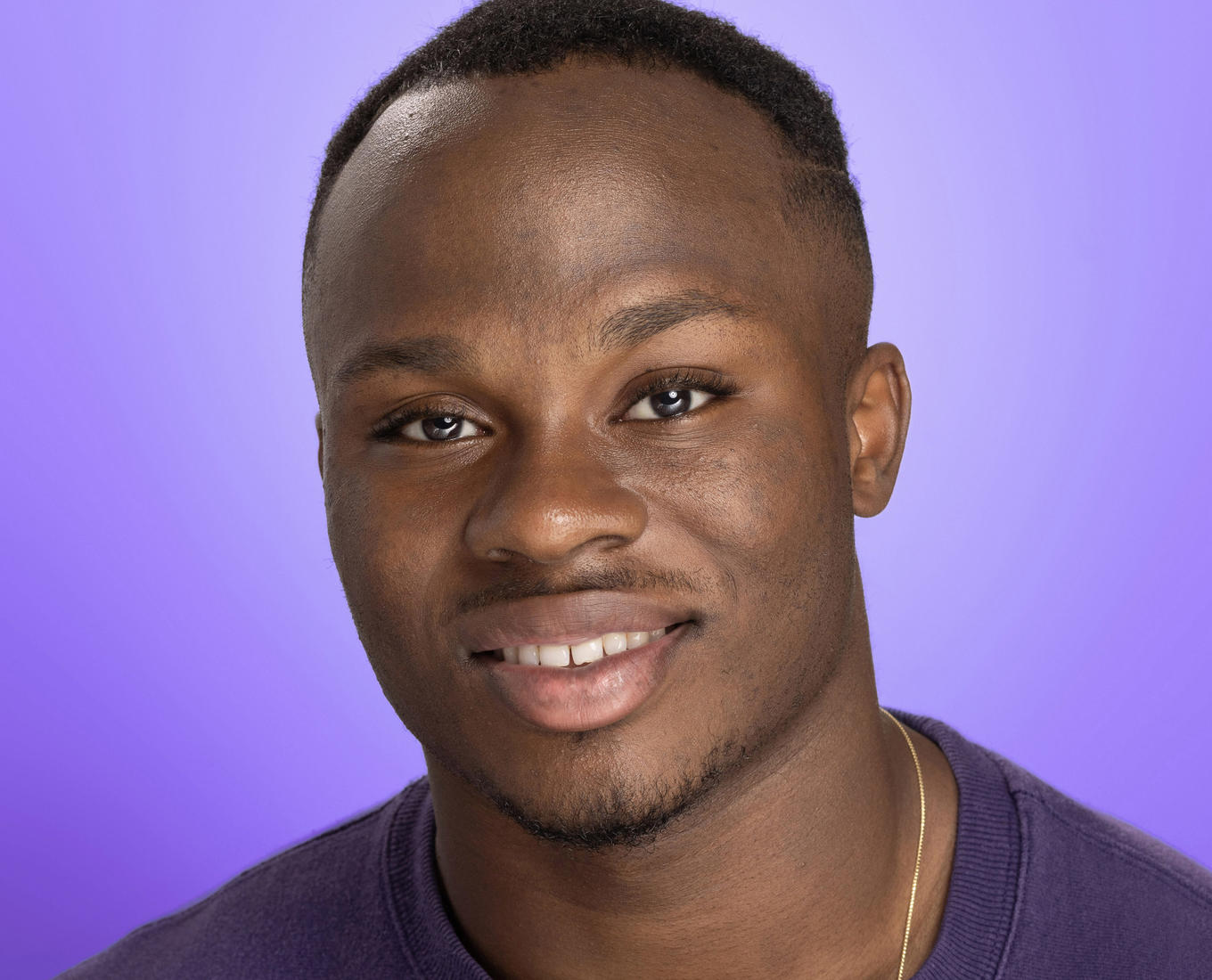 A portrait of a smiling young man wearing a Holy Cross sweatshirt