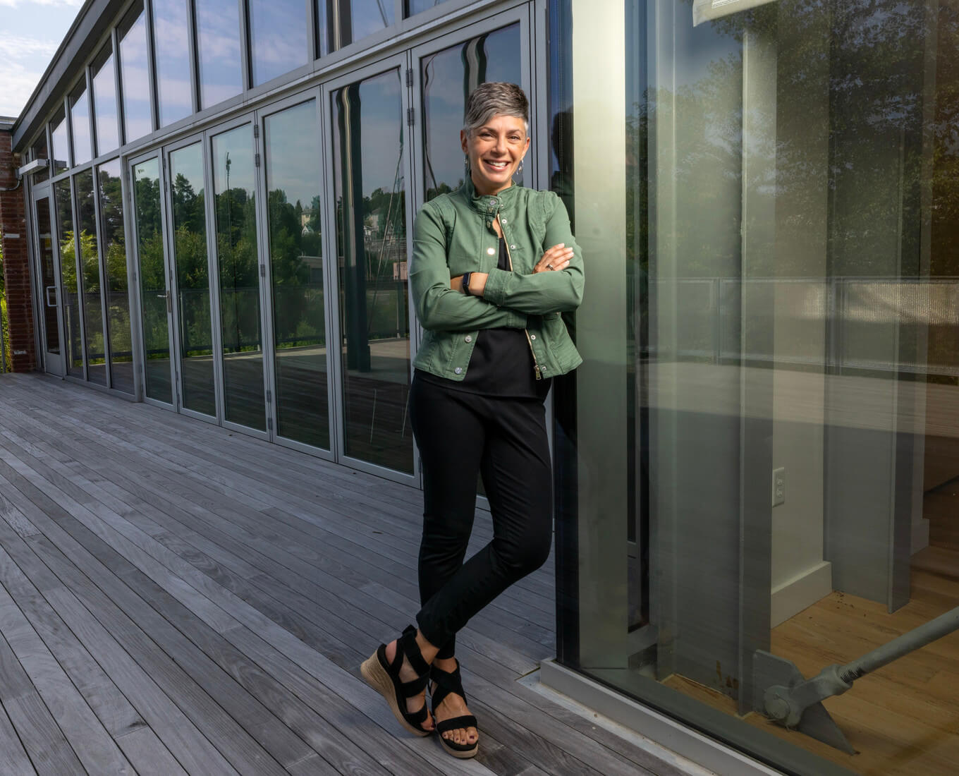 women leans against glass building