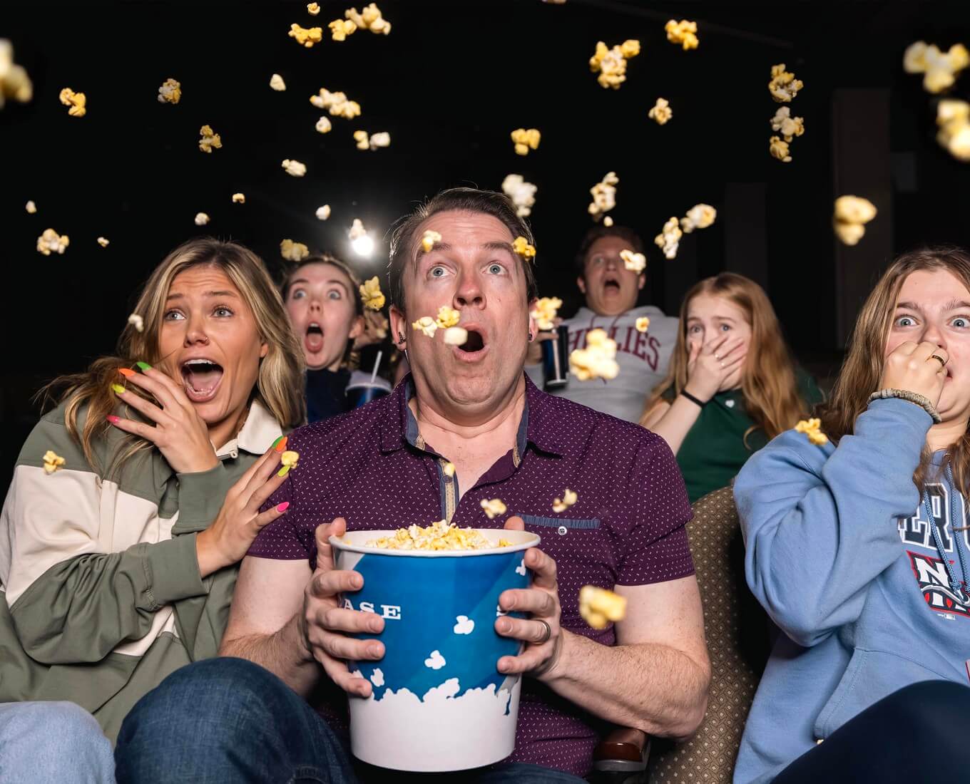 People with popcorn in movie theater