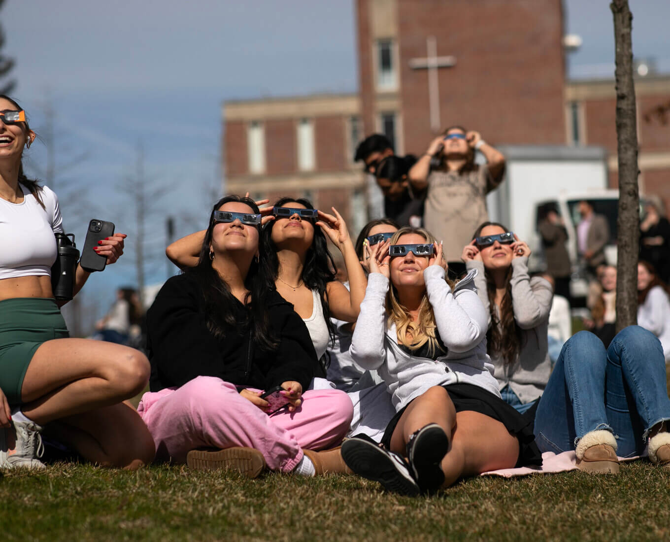 People wearing glasses stare at the sky.