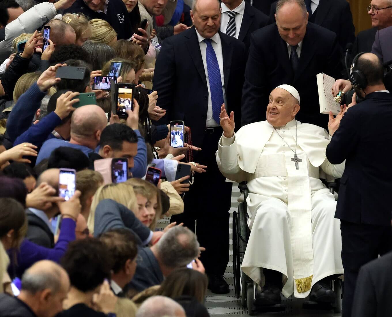 Man in wheelchair pushed through a crowd
