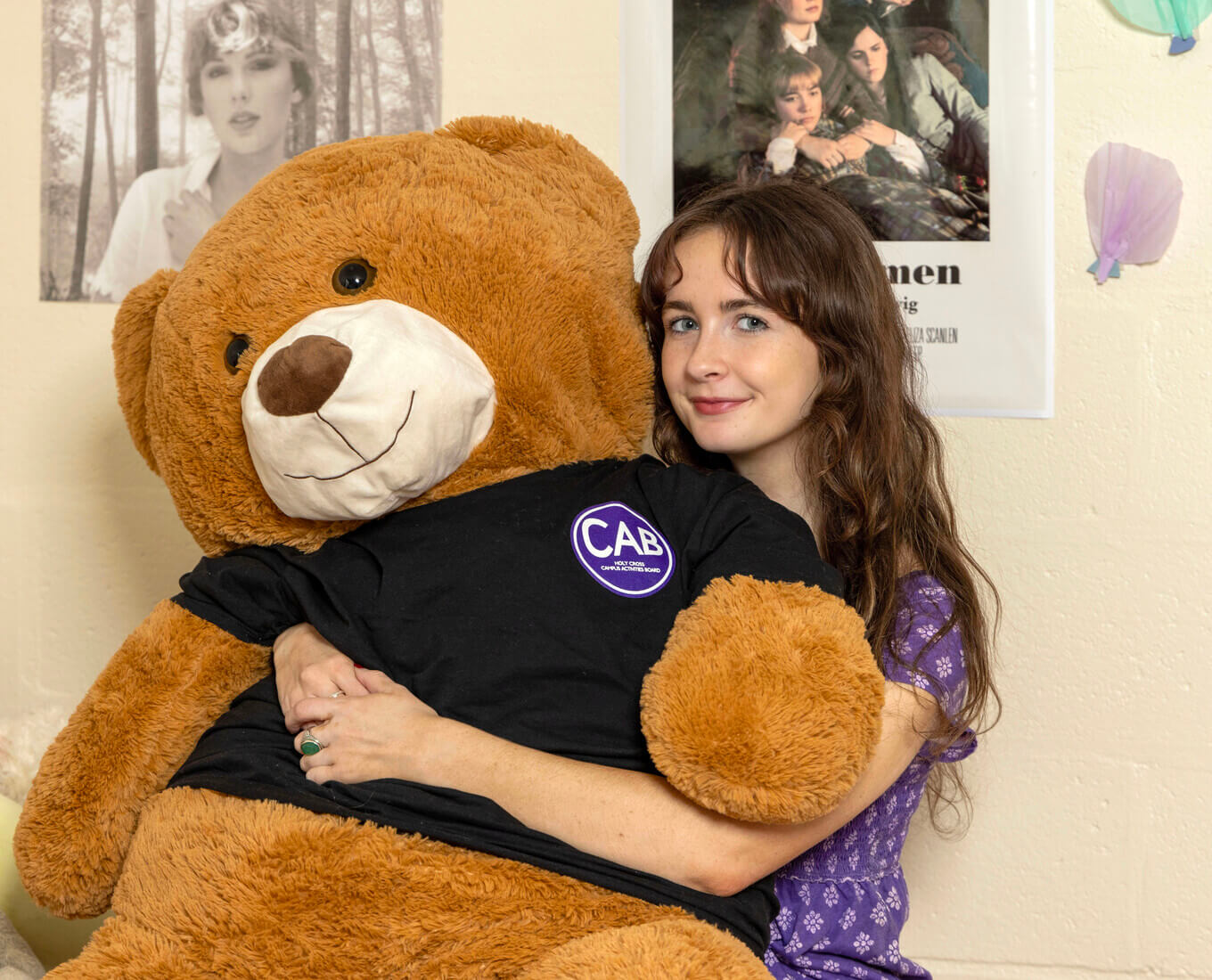 Annabeth holds her bingo prize, CAB, a giant stuffed bear
