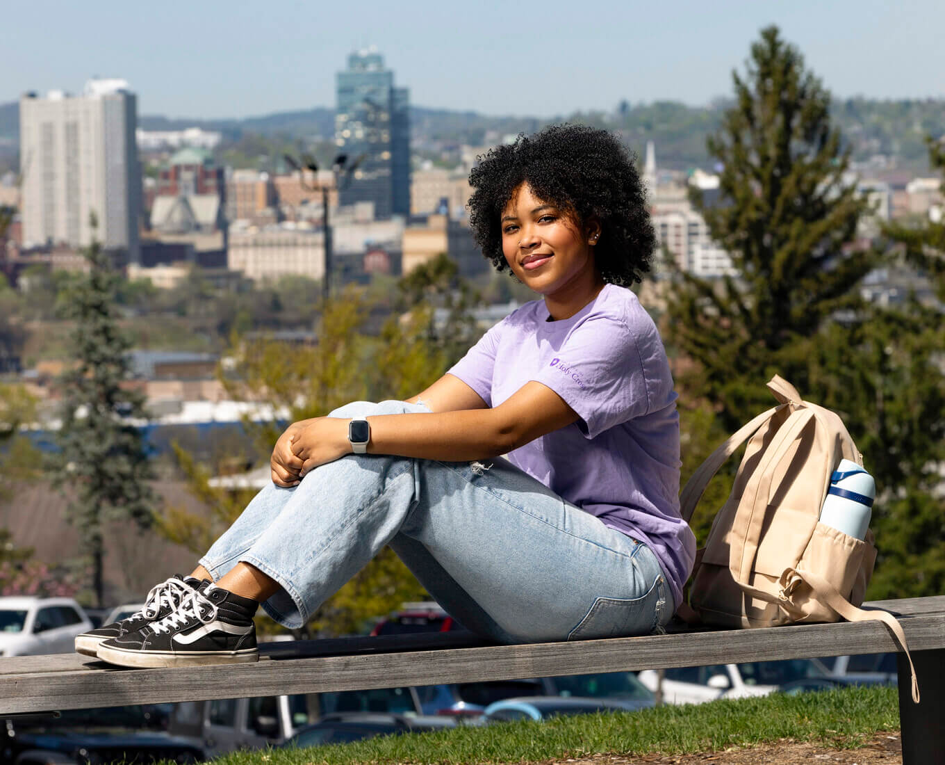 Bobbie Pitts sits on an bench on campus 