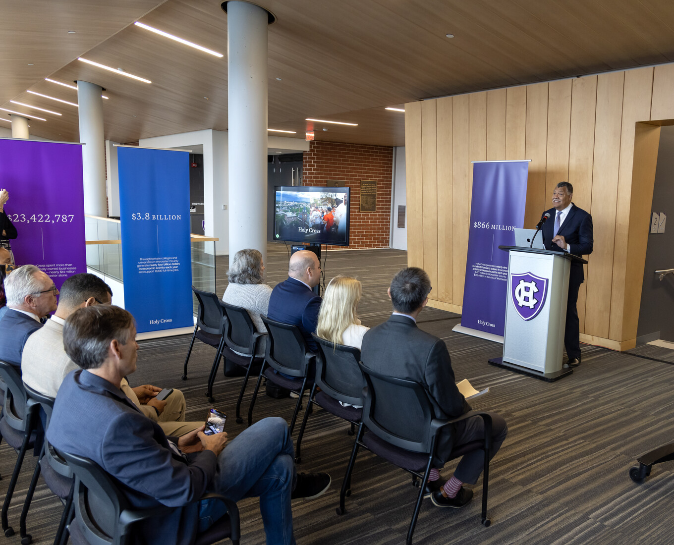 man at podium addresses crowd