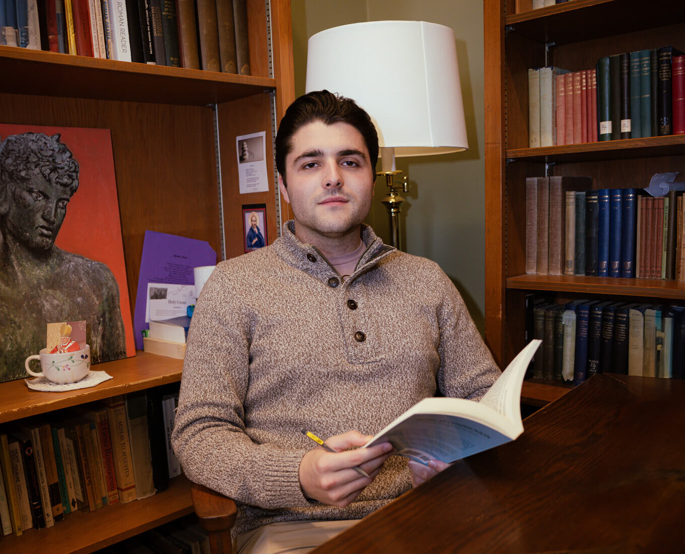 Young man with book at desk