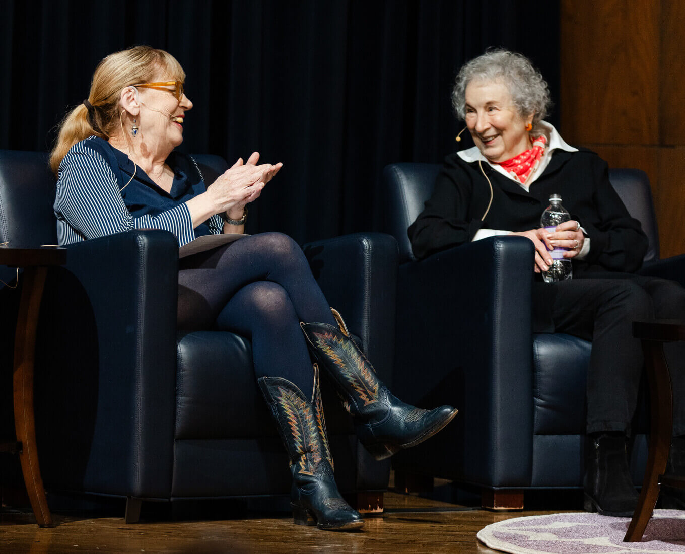 Two woman sit in chairs talking
