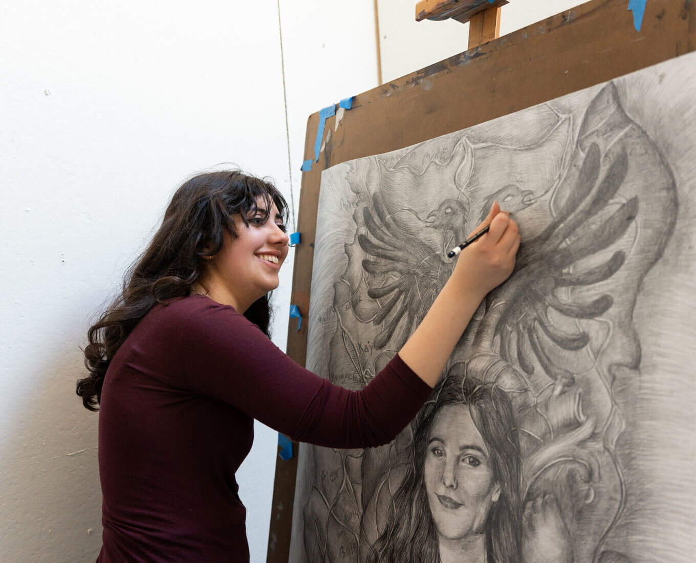 Sophie Sundaram working on a black and white drawing at an easel