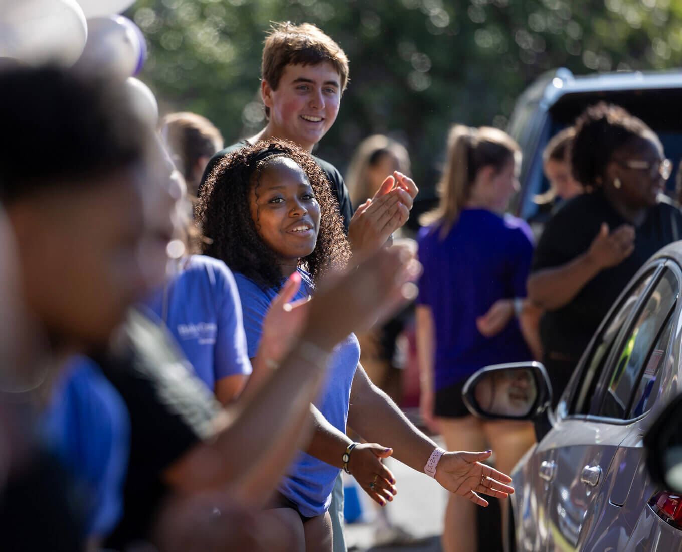 Students clapping as cars drive up