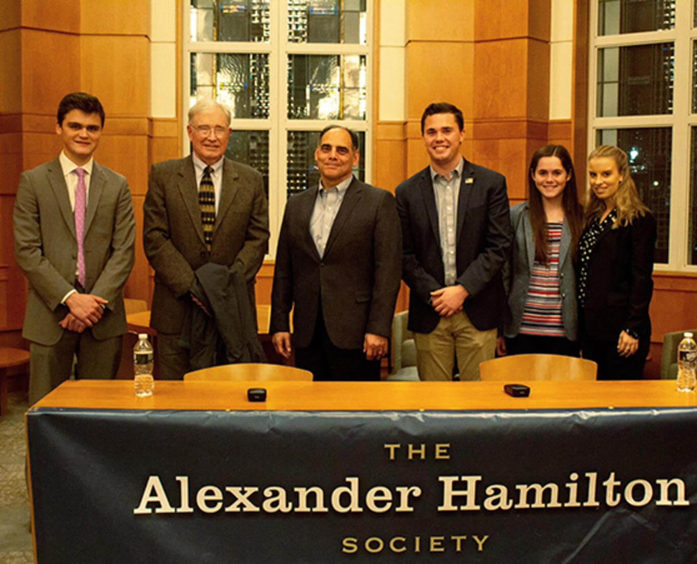 Six people in front of a banner.