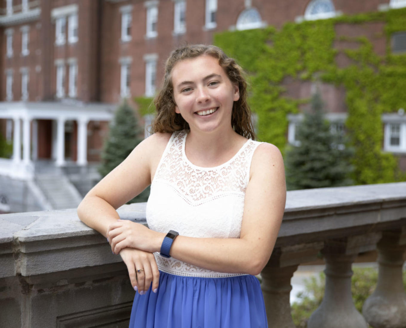 Kerry Bresnahan '22 poses on the patio of a brick building at the College of the Holy Cross.