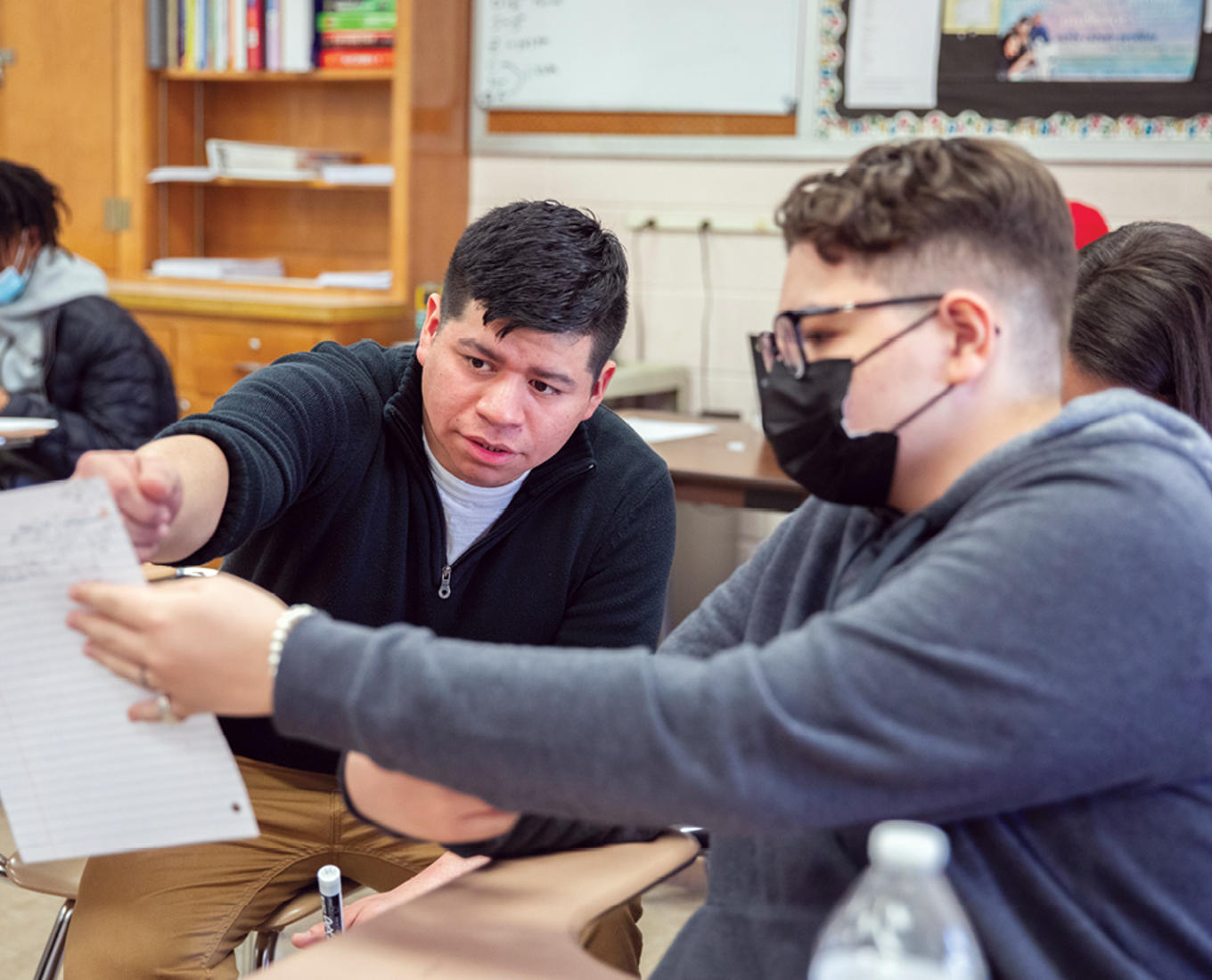 Josh Delgado '15 is reviewing classwork with a student from his Honors Algebra II class.
