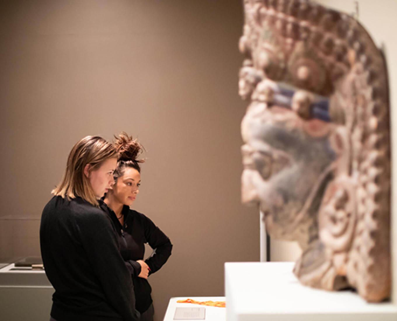 Holy Cross students are seen here admiring the objects of Buddhist devotion displayed in the Cantor Art Gallery's Dharma and Punya exhibit. Photo by Avanell Brock
