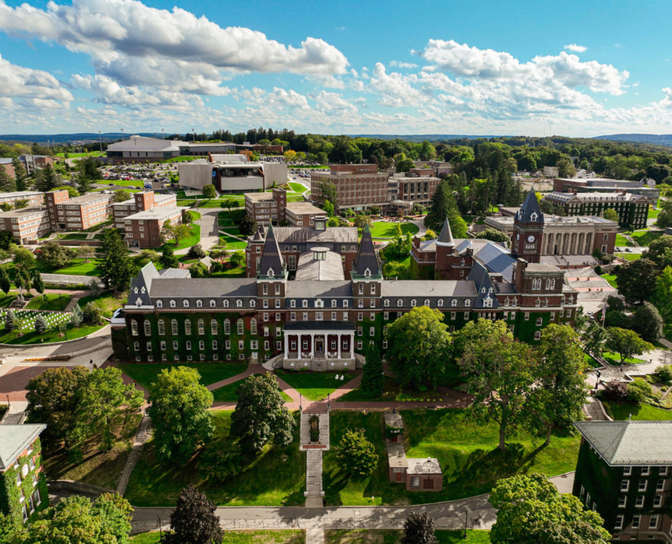 Photo taken from the sky above a college campus showing lots of green space and old brick buildings.