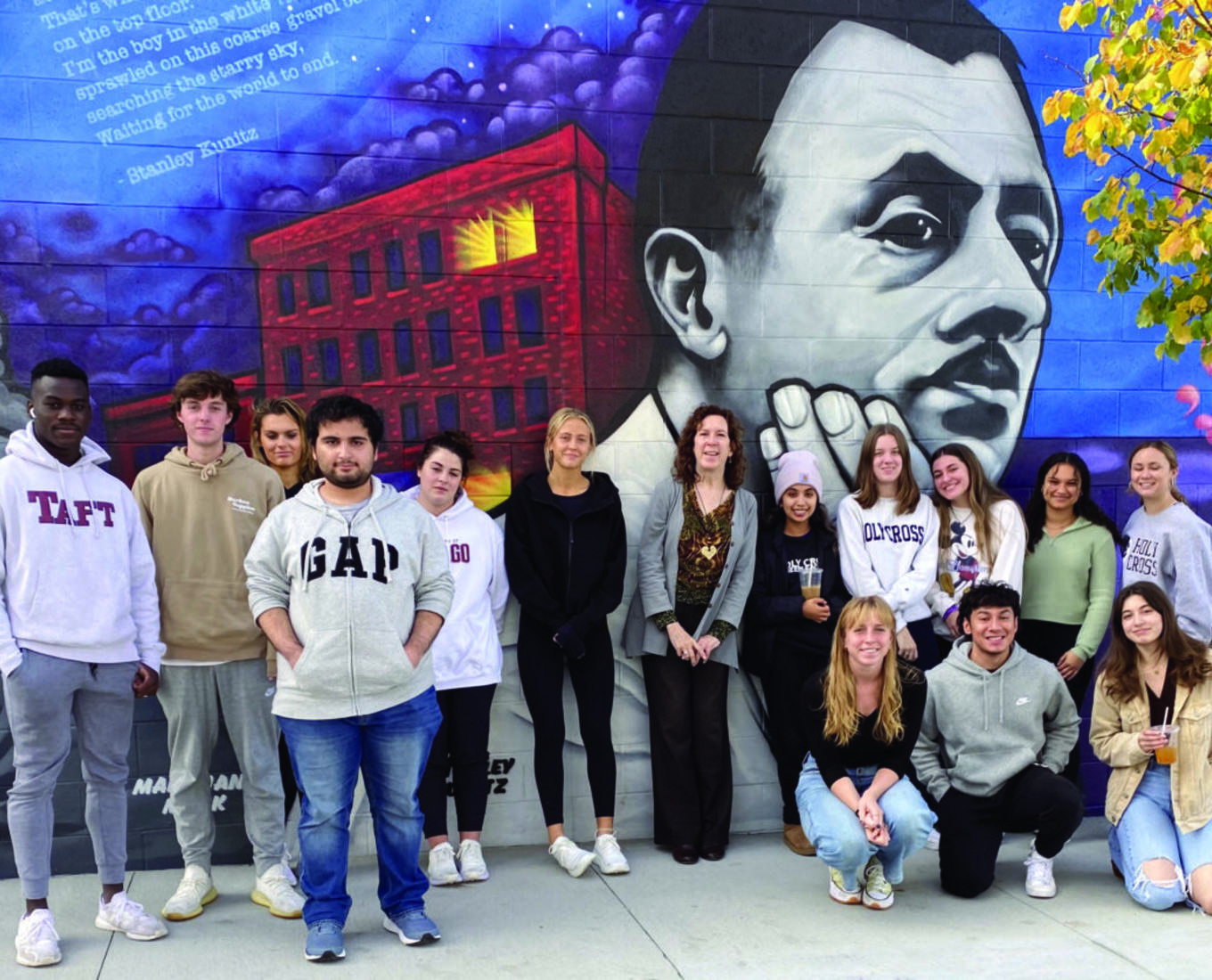 Students and professor stand in front of poet Stanley Kunitz mural in Worcester, MA.