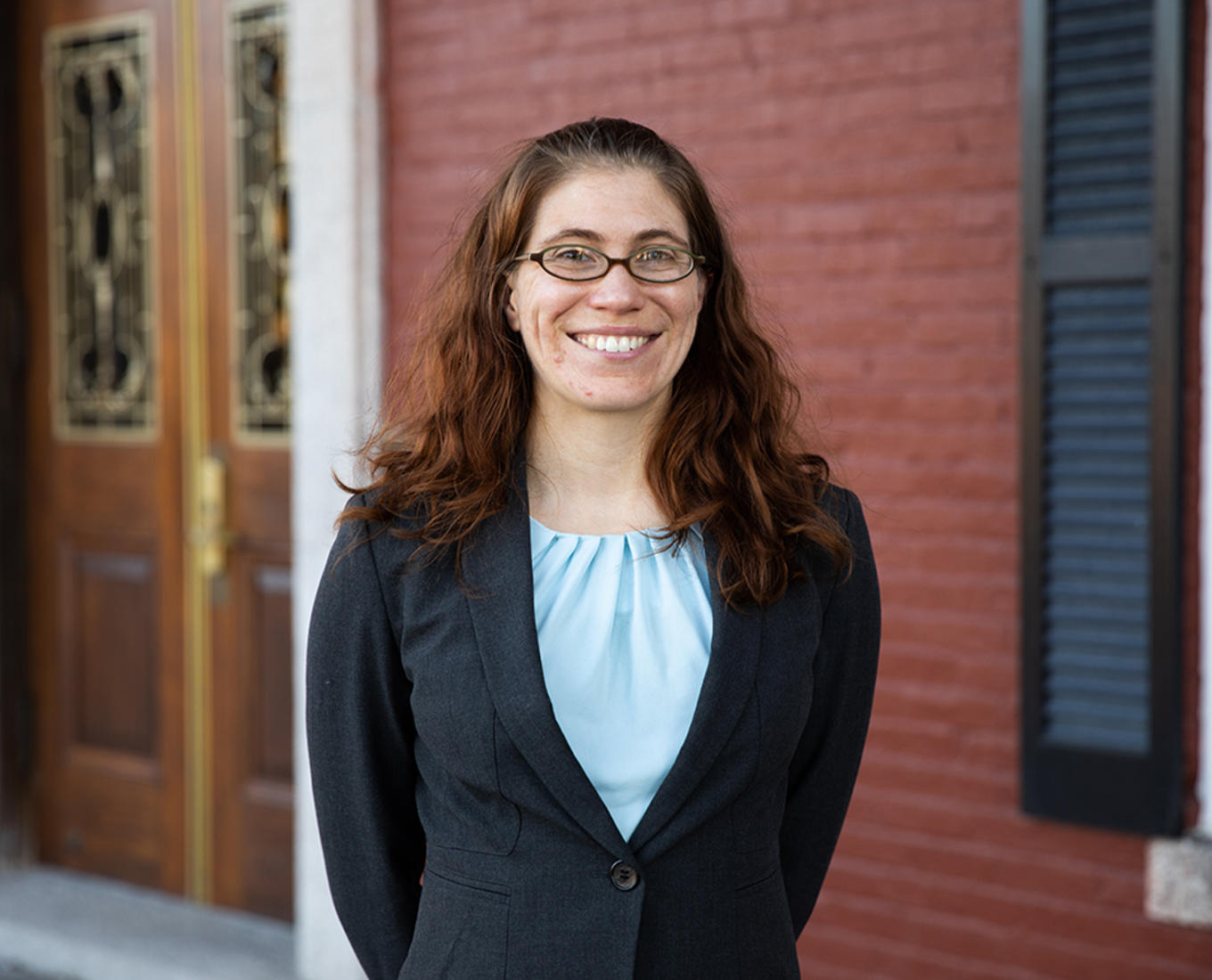 Rebecca Winarski stands in front of a door on Fenwick porch