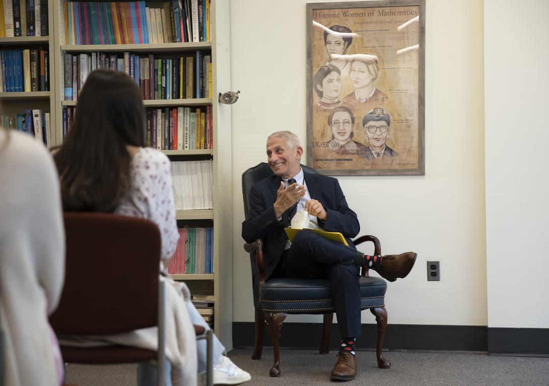 Dr. Anthony Fauci sitting in a chair laughing