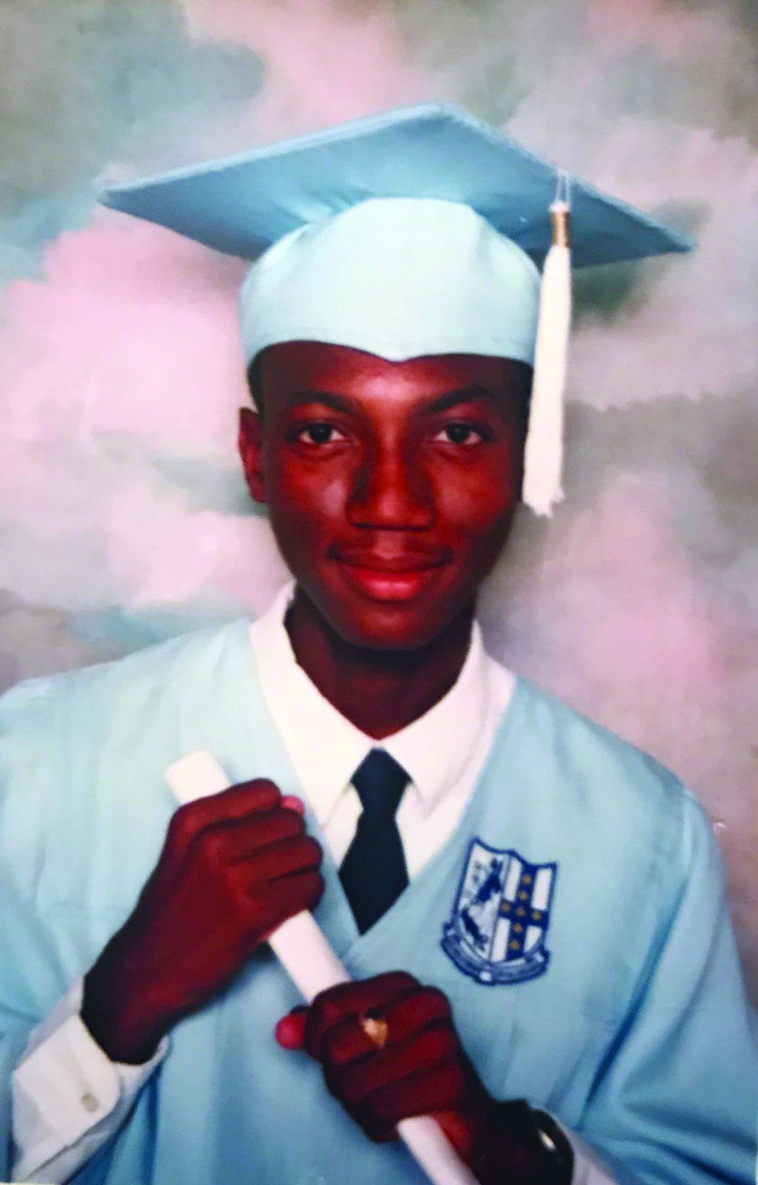 A young André Isaacs in commencement regalia in high school