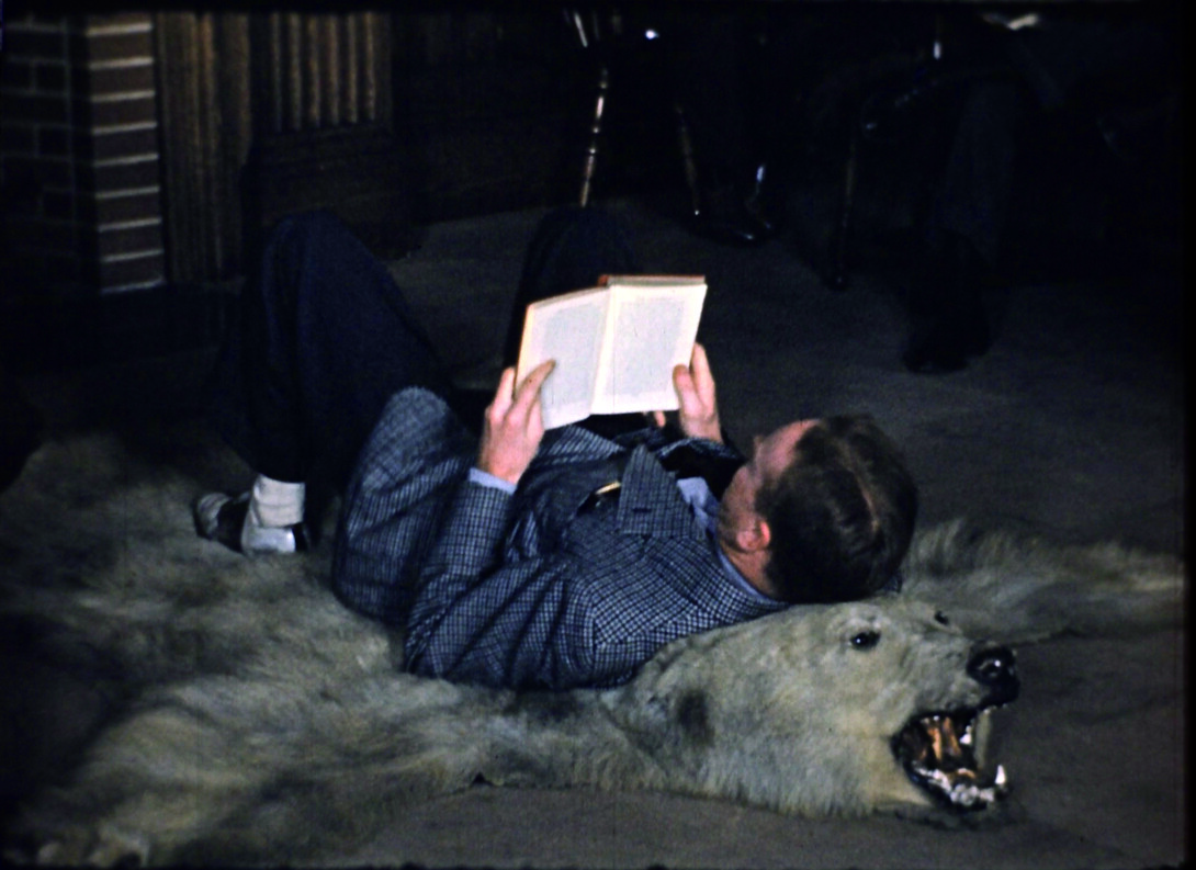 Student reading on a bearskin rug