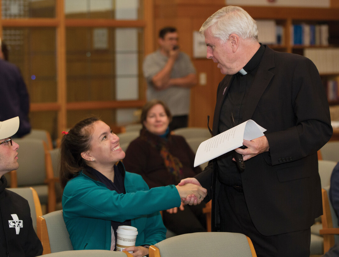 Fr. Hayes shaking the hand of a student