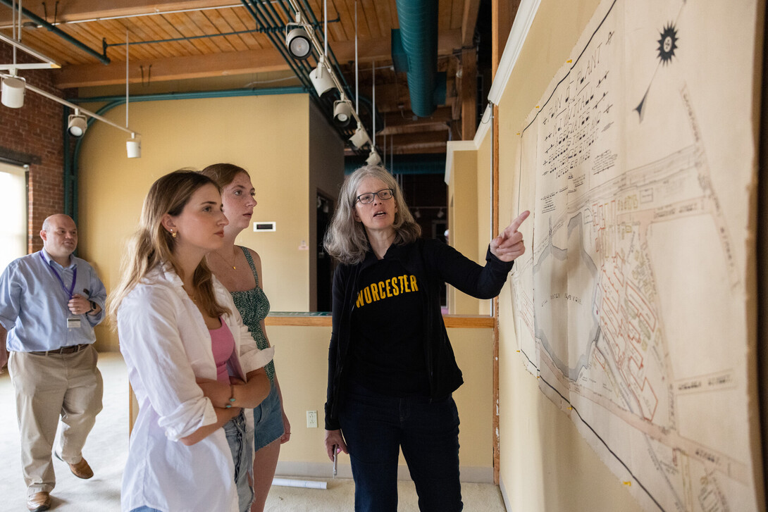 Professor pointing at a map with two students looking on