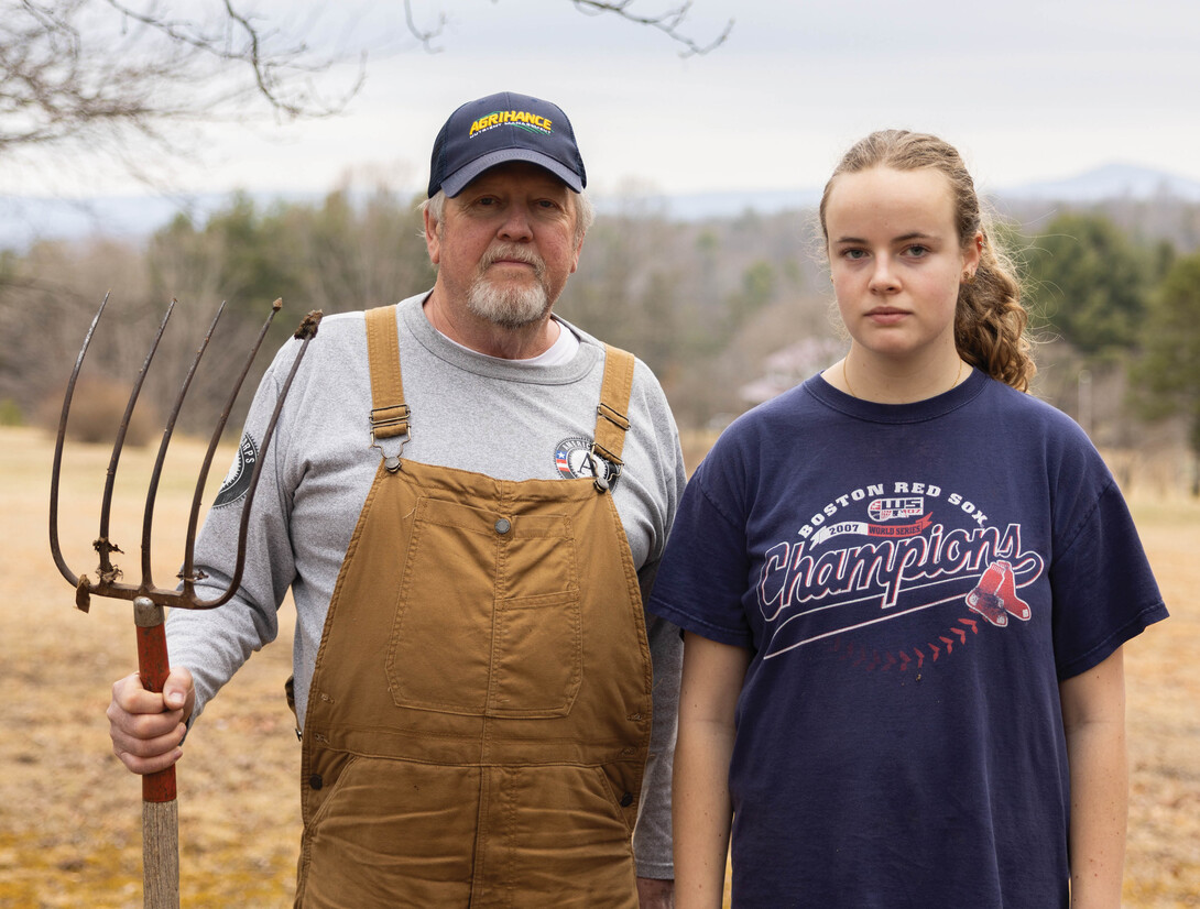 A man holding a rake and standing next to a woman