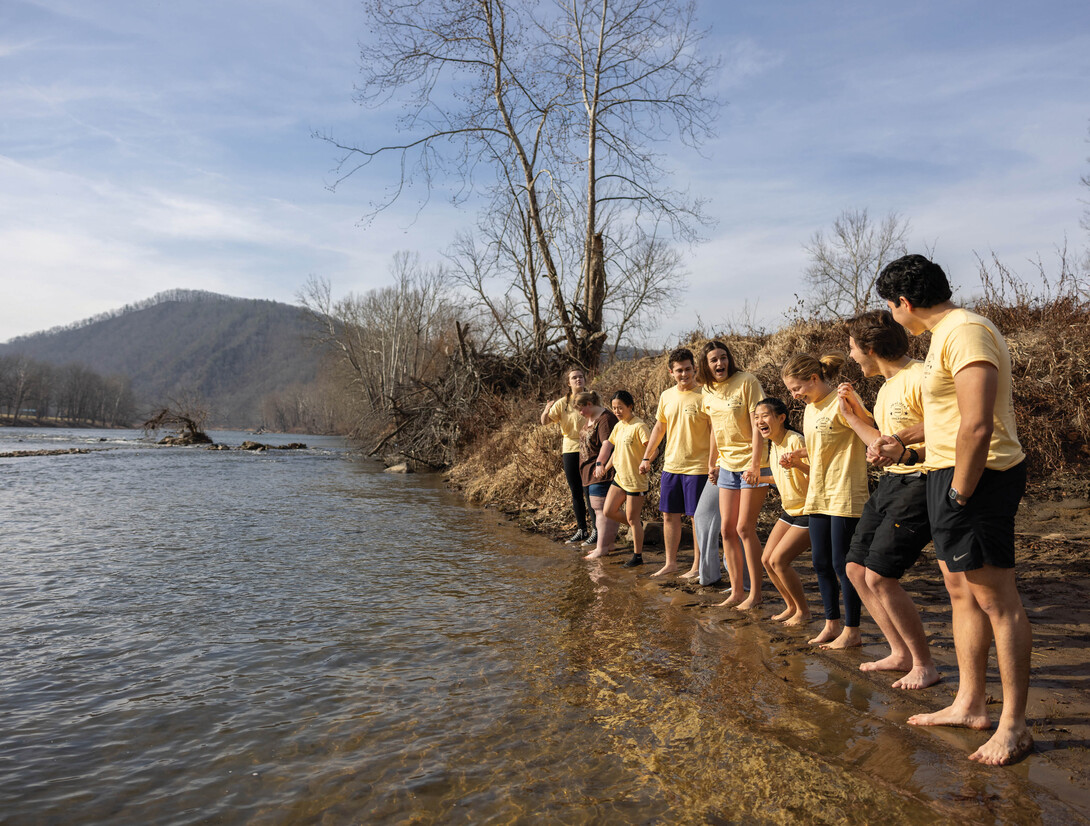 Students hold hands on the riverbank